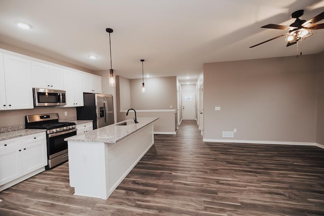 kitchen with white cabinets, hanging light fixtures, an island with sink, and appliances with stainless steel finishes