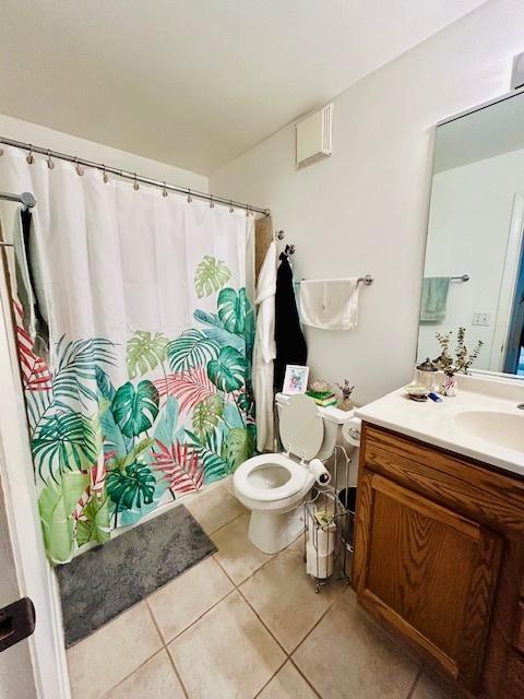 bathroom featuring tile patterned flooring, vanity, and toilet