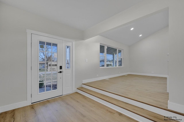 entryway with vaulted ceiling and light hardwood / wood-style flooring