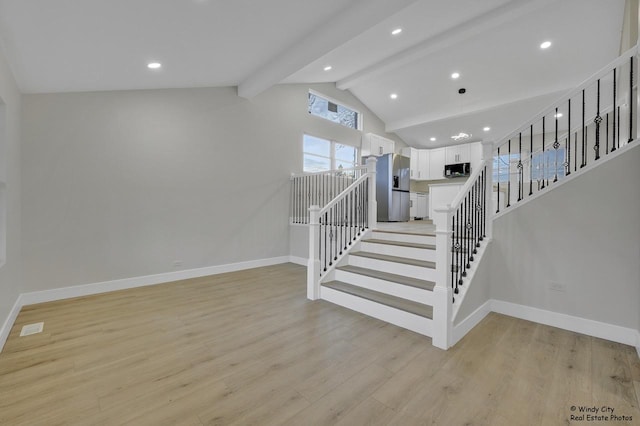 stairway with hardwood / wood-style floors and lofted ceiling with beams