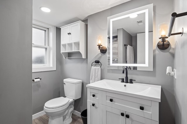 bathroom with hardwood / wood-style floors, vanity, and toilet