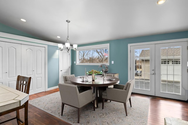 dining space with french doors, a chandelier, plenty of natural light, and hardwood / wood-style flooring