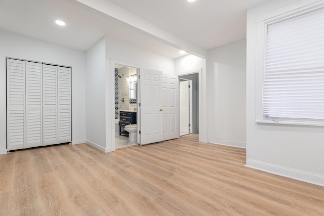 unfurnished bedroom featuring baseboards, light wood-style flooring, recessed lighting, ensuite bathroom, and beamed ceiling