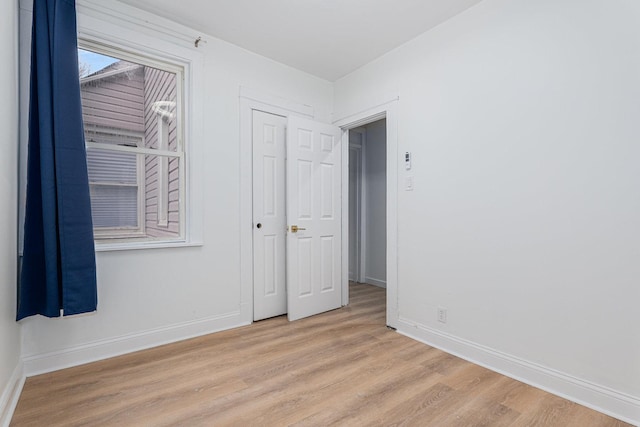 spare room with light wood-type flooring and baseboards