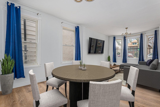 dining space featuring baseboards and light wood finished floors