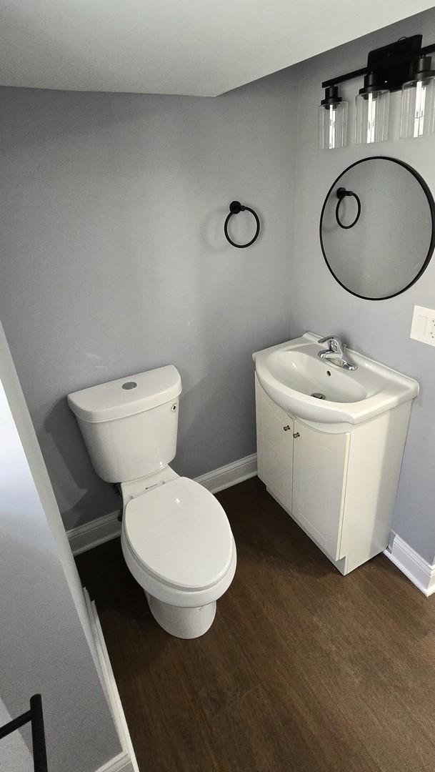 clothes washing area with washer and clothes dryer and dark hardwood / wood-style floors