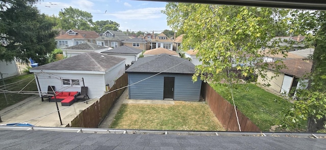 back of house with a lawn and an outdoor structure