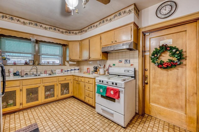 kitchen featuring backsplash, ceiling fan, sink, light brown cabinets, and white stove