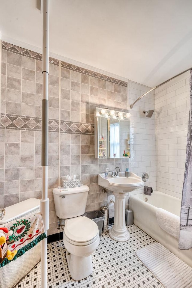 bathroom featuring tile patterned floors, shower / bath combination with curtain, toilet, and tile walls