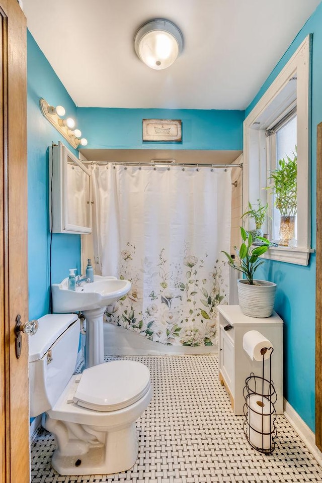 bathroom featuring curtained shower and toilet