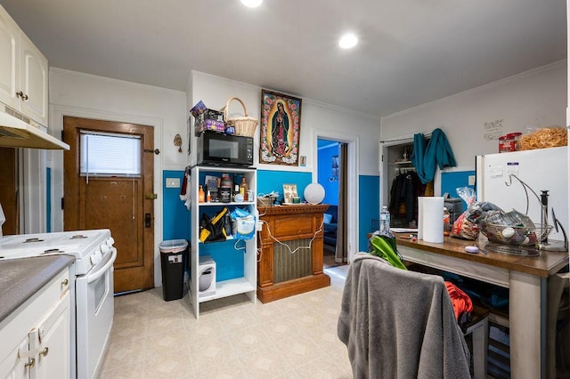 interior space with white cabinets and white electric stove