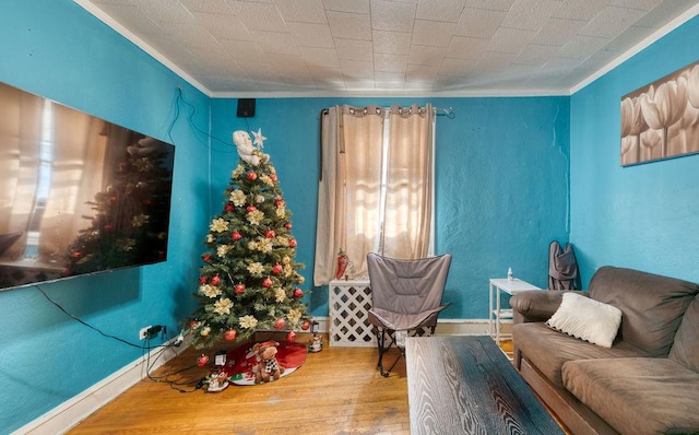 living room with hardwood / wood-style flooring and crown molding