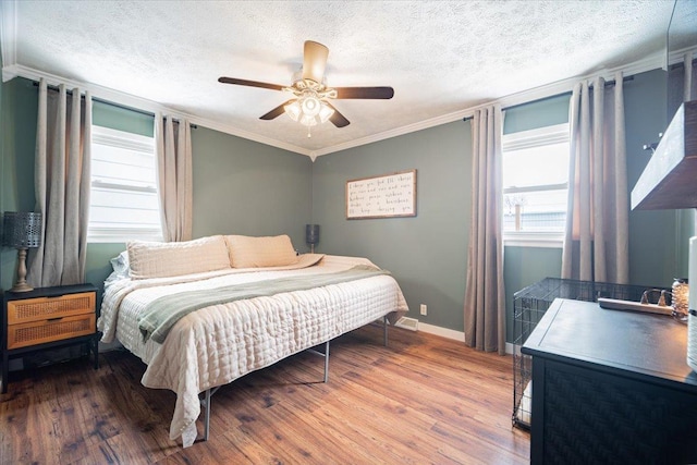 bedroom featuring wood-type flooring, a textured ceiling, ceiling fan, and crown molding