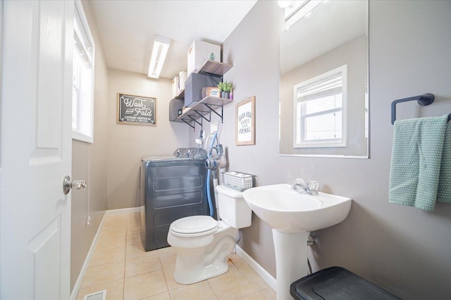 bathroom with tile patterned floors, sink, toilet, and washer / dryer