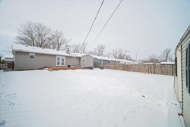 snow covered house featuring a deck