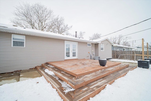 snow covered deck featuring central air condition unit and french doors