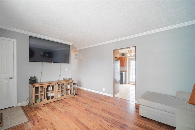 living room with ceiling fan, wood-type flooring, a textured ceiling, and ornamental molding