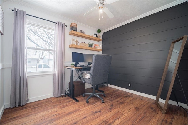 home office featuring hardwood / wood-style floors, crown molding, wooden walls, ceiling fan, and a textured ceiling