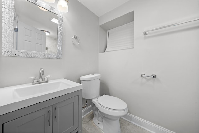 bathroom with tile patterned flooring, vanity, and toilet