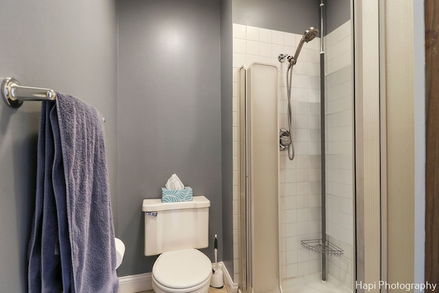 bathroom with toilet and a shower with shower door