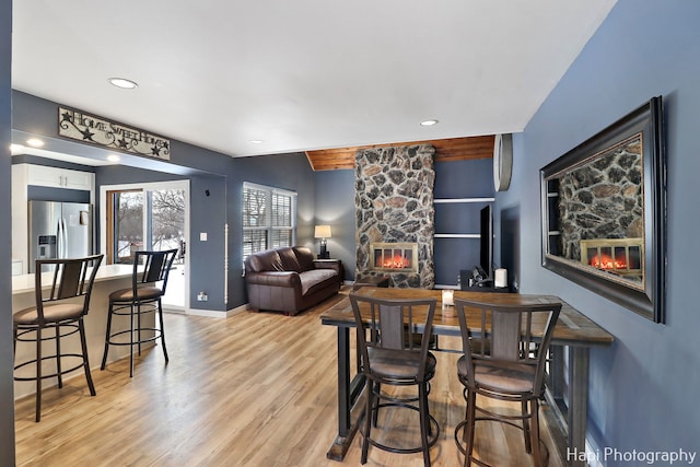 dining area featuring light hardwood / wood-style flooring and a stone fireplace