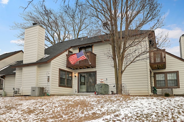 snow covered house with a balcony and central AC