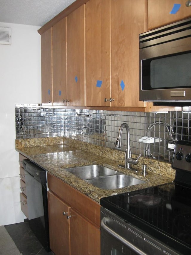 kitchen featuring sink, stainless steel appliances, stone countertops, and tasteful backsplash