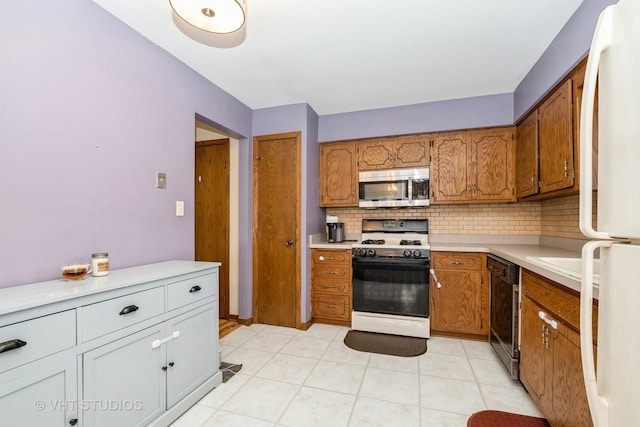 kitchen with tasteful backsplash, light tile patterned flooring, and white appliances