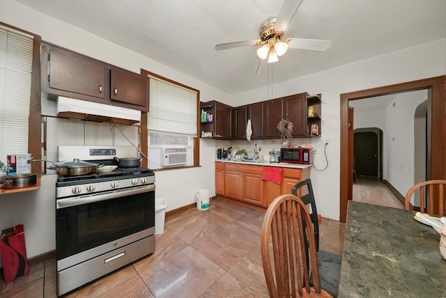 kitchen featuring ceiling fan, sink, tasteful backsplash, stainless steel range with gas cooktop, and cooling unit