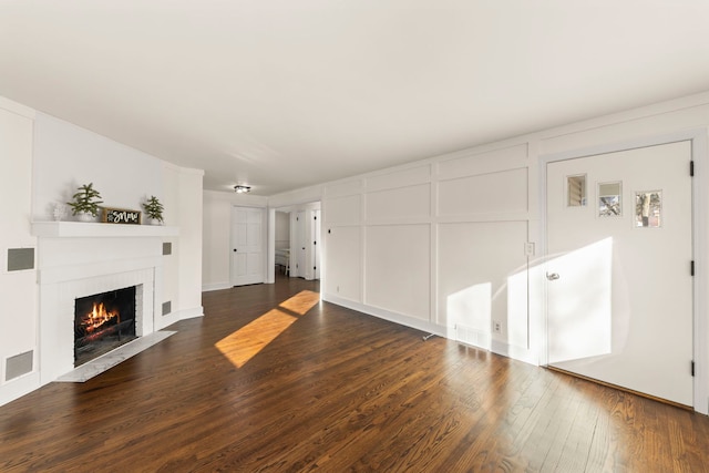 unfurnished living room with a fireplace and dark hardwood / wood-style floors