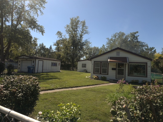 view of front of house featuring an outbuilding, a front yard, and a garage