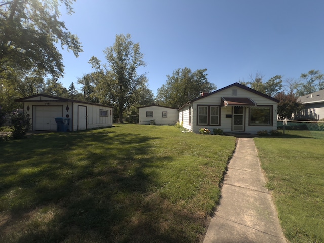 view of yard with a garage and an outbuilding