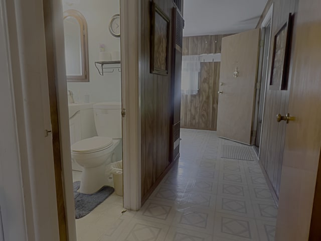 bathroom with wooden walls and toilet