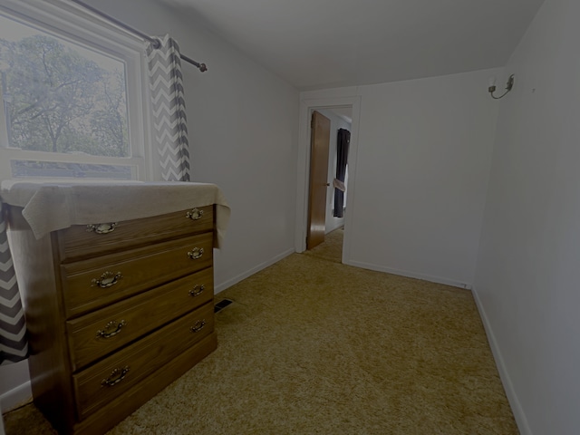 hallway featuring light colored carpet