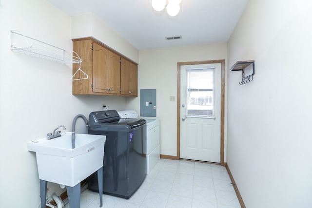 clothes washing area featuring cabinets, washer and dryer, sink, and electric panel