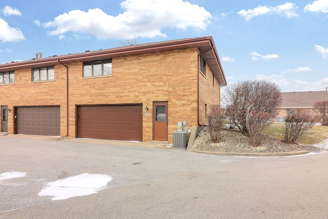 exterior space featuring a garage and cooling unit