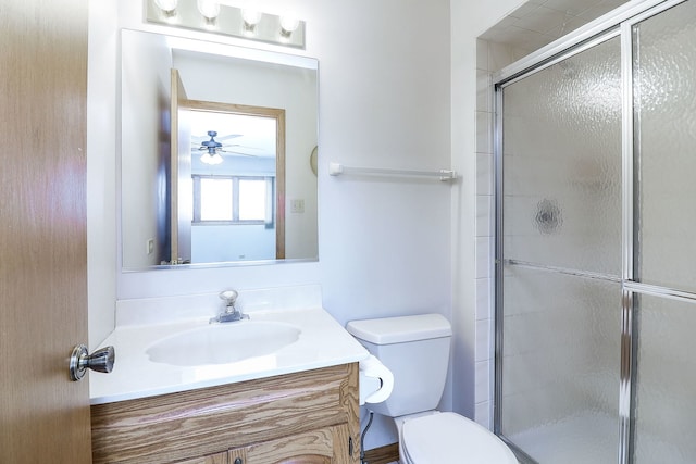 bathroom with vanity, a shower with shower door, and toilet