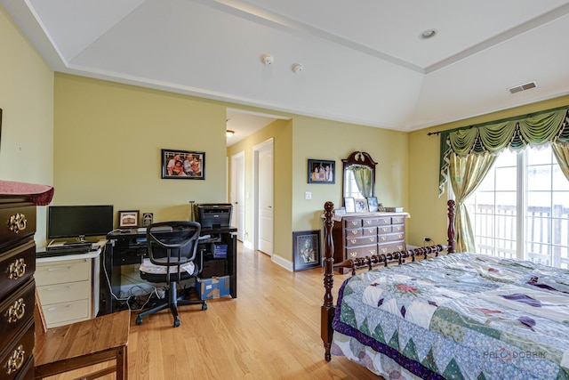 bedroom with a tray ceiling and light hardwood / wood-style flooring