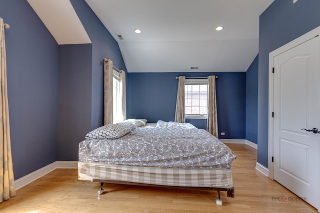 bedroom with light hardwood / wood-style flooring and lofted ceiling