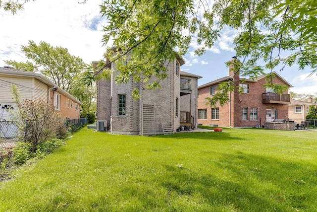 back of property featuring central AC unit and a lawn