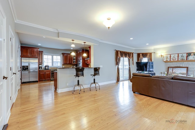 living room featuring light wood-type flooring, crown molding, and wine cooler