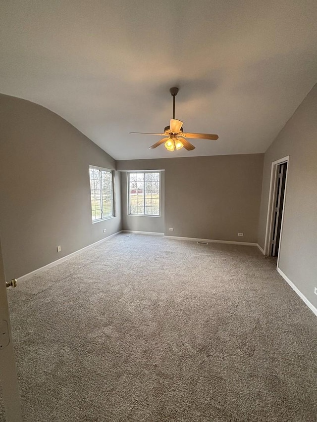 carpeted empty room with ceiling fan and lofted ceiling