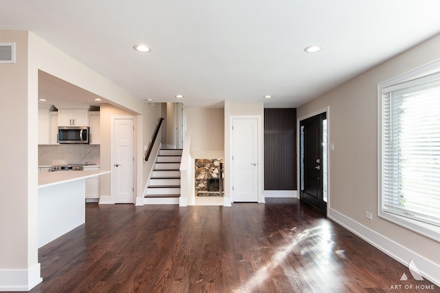 unfurnished living room with plenty of natural light and dark wood-type flooring