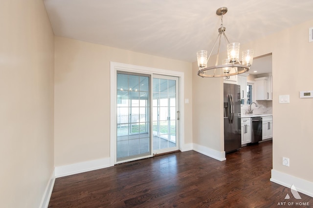 unfurnished dining area with dark hardwood / wood-style floors, a notable chandelier, and sink