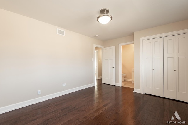 unfurnished bedroom featuring connected bathroom, a closet, and dark hardwood / wood-style floors