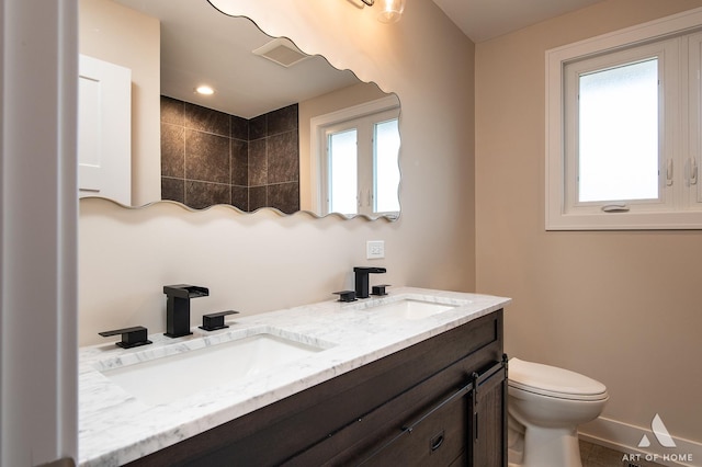 bathroom featuring vanity, toilet, and a wealth of natural light