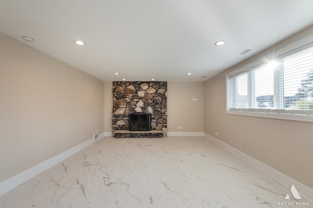 unfurnished living room with a stone fireplace