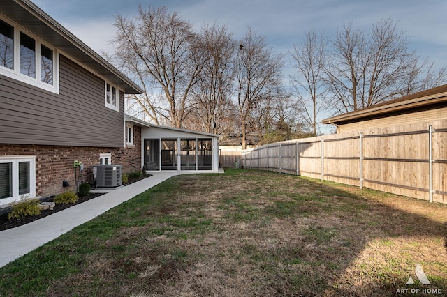 view of yard with a sunroom and central AC unit