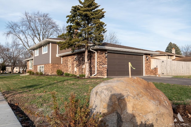 tri-level home featuring a garage and a front lawn