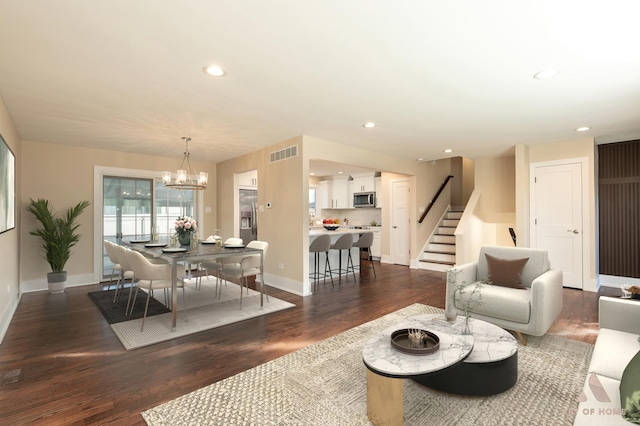 living room featuring dark wood-type flooring and an inviting chandelier